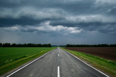 Gök gürültülü bulutların arasından, uzaklığa giden bir yol..