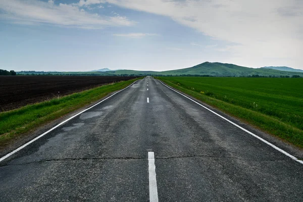 De weg die naar de bergen leidt na de regen. — Stockfoto