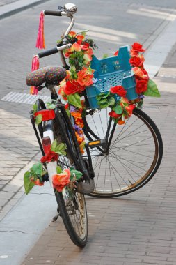 Amsterdam 'ın bisikletleri. Plastik parlak kırmızı çiçekli park edilmiş bisiklet.