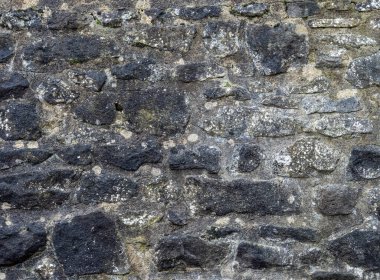 Geleneksel grungy Stone Duvarı. Kapatın. Harç ve düzensiz karartılmış taşları gösterin.