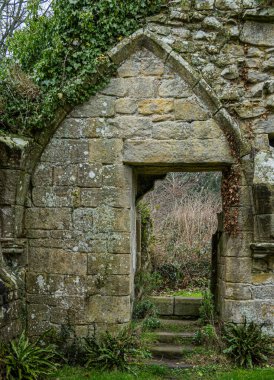 Yıpranmış kireç taşı işçiliğiyle ortaçağ manastırı kemeri
