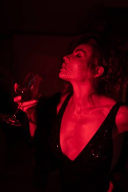 Otelde siyah elbise giyen zarif bir kadın. Retro tarzı. Kırmızı ışıkta