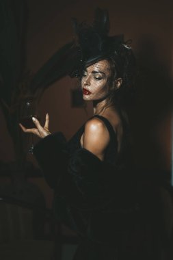 Otelde siyah elbise giyen zarif bir kadın. Retro biçimi