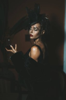 Otelde siyah elbise giyen zarif bir kadın. Retro biçimi