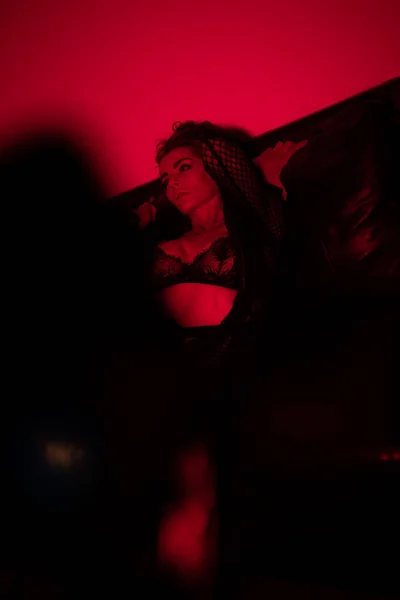 Mulher Sexy Vestindo Lingerie Preta Casaco Sentado Sofá Luz Vermelha — Fotografia de Stock