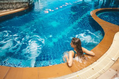 Havuz başında dinlenen çekici bir kadın.