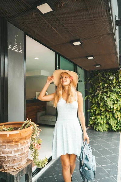 Szczęśliwa kobieta w sukience i kapeluszu stojąca w hotelu — Zdjęcie stockowe