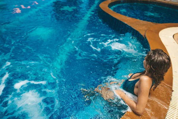 Ελκυστική γυναίκα που χαλαρώνει δίπλα στην πισίνα — Φωτογραφία Αρχείου