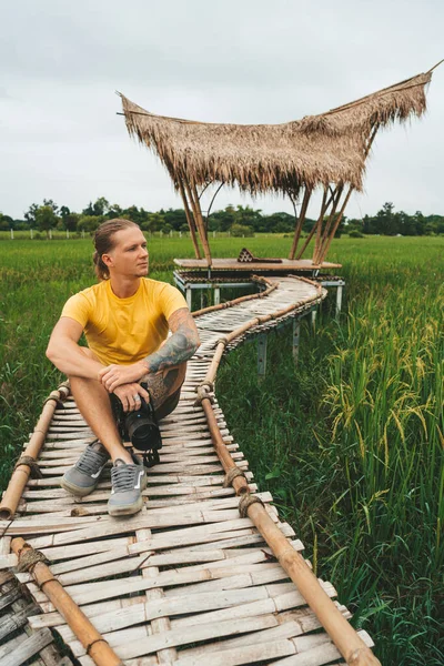 Homem Fotógrafo Camiseta Amarela Está Sentado Ponte Bambu Campo Arroz — Fotografia de Stock