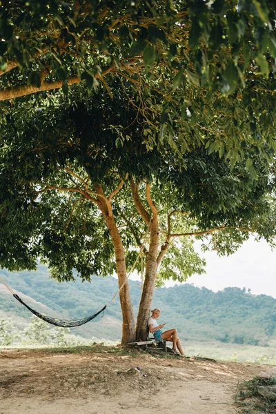 Kobieta Siedzi Pod Dużym Drzewem Używa Telefonu Punkcie Widokowym Dzielnicy — Zdjęcie stockowe