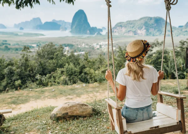 女性はスイングに座っていて タイのパンガー地区の岩の素晴らしい景色を楽しんでいます — ストック写真