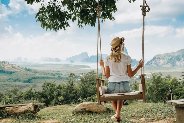 女性はスイングに座っていて タイのパンガー地区の岩の素晴らしい景色を楽しんでいます — ストック写真