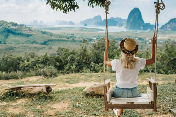 女性はスイングに座っていて タイのパンガー地区の岩の素晴らしい景色を楽しんでいます — ストック写真