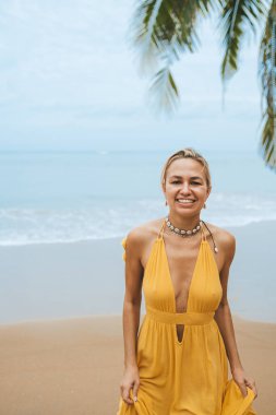 Tayland 'da kumsalda yürüyen mutlu bir kadın.