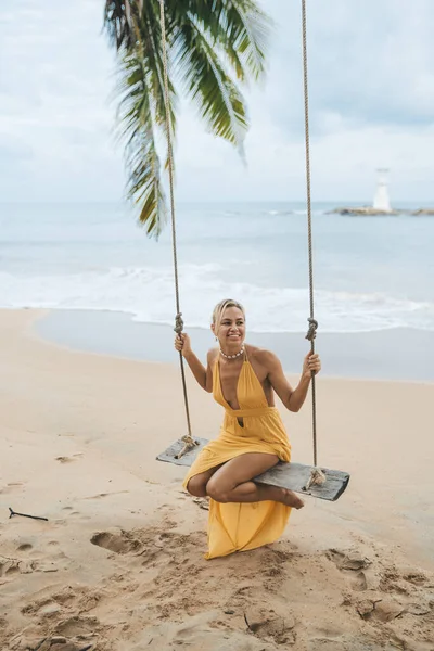 タイの花王ラックのビーチでスイング上の黄色のドレススイングの若い女性 — ストック写真