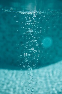 Yüzme havuzunda su kabarcıkları. Kabarcıklı suyun bulanık arka planı