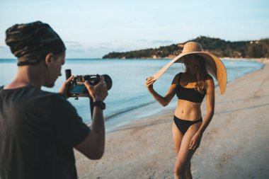 Bikini ve büyük hasır şapka giyen fotoğraf mankeni.