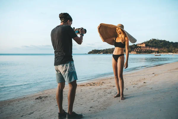 ビキニと大きな藁帽子を身に着けている写真家の撮影モデル — ストック写真