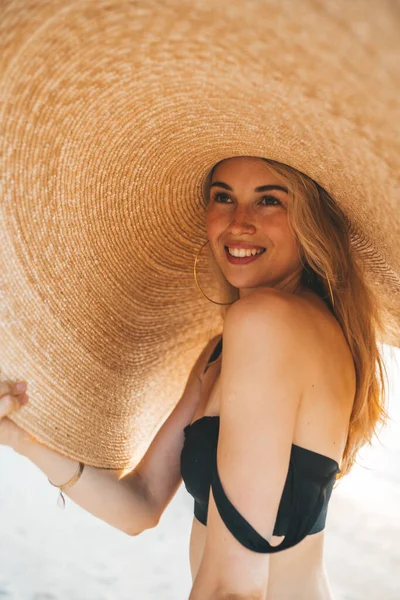 해변에서 포즈를 취하는 여성의 수영복을 유행하는 모자를 매력적 — 스톡 사진