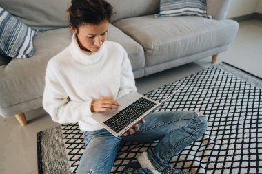 Mutlu kız hafta sonunu evde oturup dizüstü bilgisayarda film izleyerek geçiriyor.