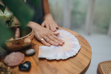 Kadın kafede masada Tarot kartları okuyor.