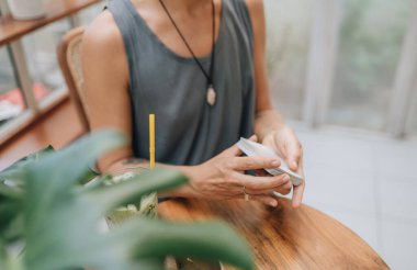 Kadın kafede masada Tarot kartları okuyor.