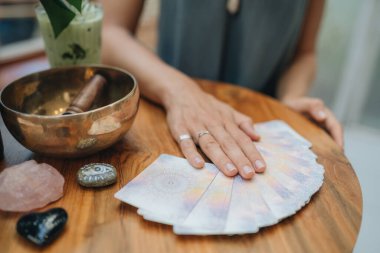 Kadın kafede masada Tarot kartları okuyor.
