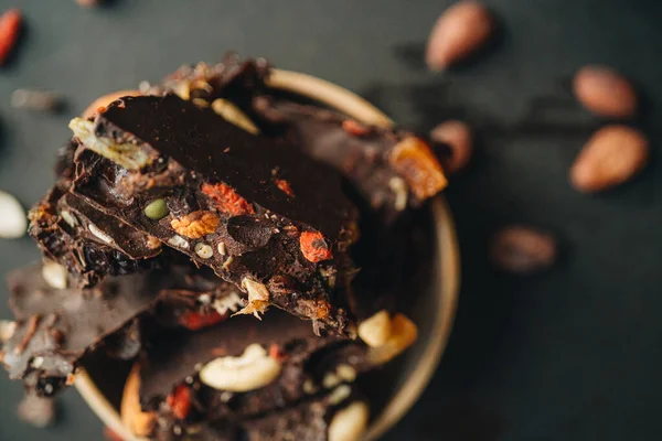 Темный Шоколад Сухофруктами Ягодами Орехами Вкусный Десерт Тёмном Фоне — стоковое фото