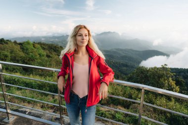 Tayland 'ın en yüksek noktasında kırmızı ceket giyen bir kadın. Tayland 'ın en yüksek noktası Doi Inthanon