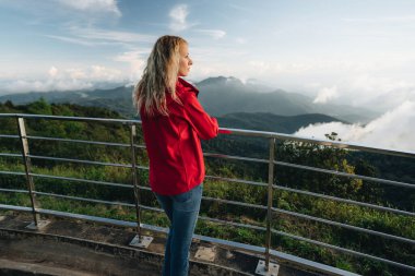 Tayland 'ın en yüksek noktasında kırmızı ceket giyen bir kadın. Tayland 'ın en yüksek noktası Doi Inthanon