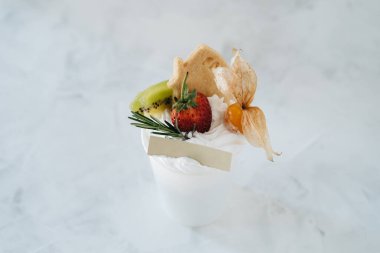 Krem şantili ve beyaz arkaplanlı bir fincan tatlı.