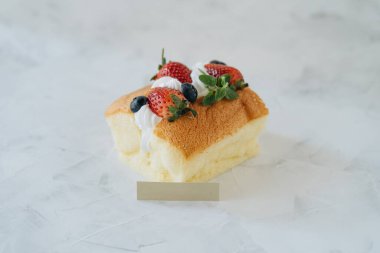 Krem şantili bisküvi ve beyaz arka planda çilek.