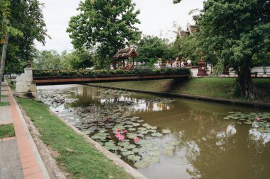 Fıskiyeleri, büyük ağaçları ve kıyılarında caddeleri olan bir kanalı izleyin. Chiang Mai, Tayland.