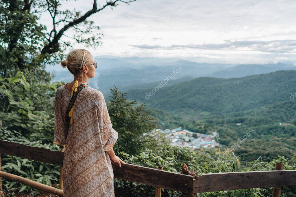 Yong woman watching Sunset in the Mountains at Doi Pui Viewpoint Doi Suthep-Pui National Park Chiang Mai Northern Thailand.