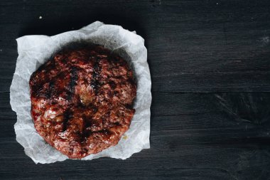 Cooked ground beef meat steak cutlets on black background.