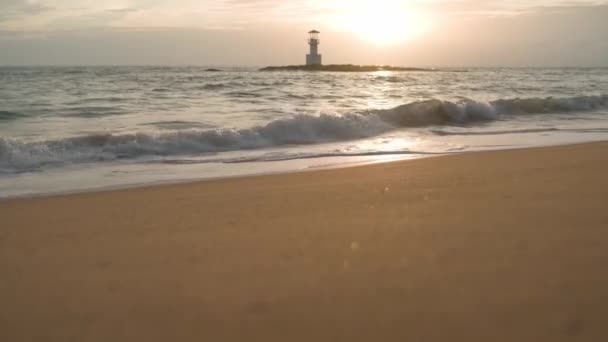 Paisagem de praia ao pôr-do-sol. Ondas no mar. Farol — Vídeo de Stock