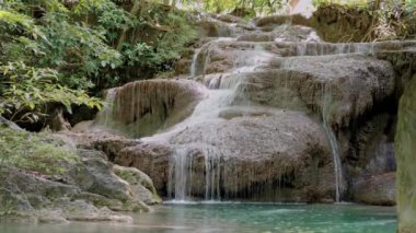 Şelale, Erawan Şelalesi yeşil ormanda zümrüttür ve Tayland 'ın Kanchanaburi eyaletinde yağmur ormanıdır. El kamerasıyla.
