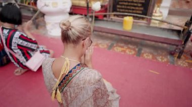 Wat Phrathat Doi Suthep Theravada Budist tapınağında dua eden kadın, Tayland 'ın Chiang Mai eyaletinde. El kamerasıyla.