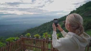 Kadın, Tayland 'ın kuzeyindeki Mon Jam' de çilek tarlasında güneşin doğuşunun fotoğrafını çekiyor. El kamerasıyla.