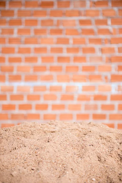 Песок и кирпичная стена — стоковое фото