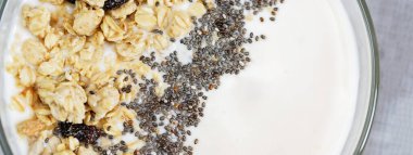 Sağlıklı kahvaltı içeceği üstü granola ve chia tohumlarıyla kaplı. Kapat. Lezzetli meyve suyu kasesi. Çiğ vejetaryen yemeği. Seçici odaklanma. Düz Yatay