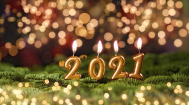 Tatil geçmişi. Mutlu yıllar 2021. 2021 yılının sayıları Bokeh şenlik ışıl ışıl arka planında yanan altın mumlar tarafından yapıldı. Yeni yılı kutluyoruz, yakın plan. Metin için boşluk