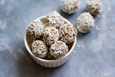 Sağlıklı çiğ enerji topları, kakao, hindistan cevizi, susam, beyaz arka planda chia. Yuvarlak yulaf, fındık ve hurma içeren sağlıklı ev yapımı paleo çikolata enerji topları. Çiğ vejetaryen sağlıklı tatlı, seçici odaklanma