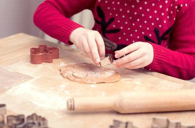 Kızıl saçlı çocuk mutfakta Noel için kurabiye pişirir. Mutlu Noeller ve mutlu tatiller. Çocuklar zencefilli ekmek yapıyor. çocuklu zencefilli bisküvi hazırlama