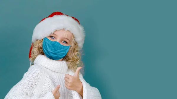 코로나 바이러스 유행성 전염병과 크리스마스 모자를 소녀가 배경에 의약품 마스크를 — 스톡 사진