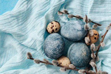 Mavi arka planda mavi Paskalya yumurtaları. Doğal olarak mermer taşlı amber çiçeğiyle boyanmış yumurtalar. Eko boya. Mutlu Paskalyalar.