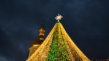 Hafif bokeh odaklanmış arkaplan. Kyiv Ana Noel ağacı ışıklarının bulanık fotoğrafı. Altın ışık efektleri. tatiller, arka plan ve aydınlatma kavramı