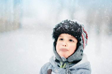 Park 'ta karlı bir çocuk. Çocuk kış ormanında oynuyor. Kış parkında eğlenen sevimli çocuk. Dışarıda karla oynamak