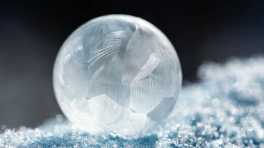Bokeh arkaplanlı donmuş baloncuk. Donmuş sabun köpüğündeki buz gibi desenler çok güzel. Kış, soğuk arka plan. Makro fotoğraf