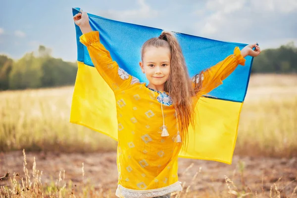 Girl blue and yellow flag of Ukraine in field. Ukraine\'s Independence Flag Day. Constitution day. 24 August. Patriotic holiday.